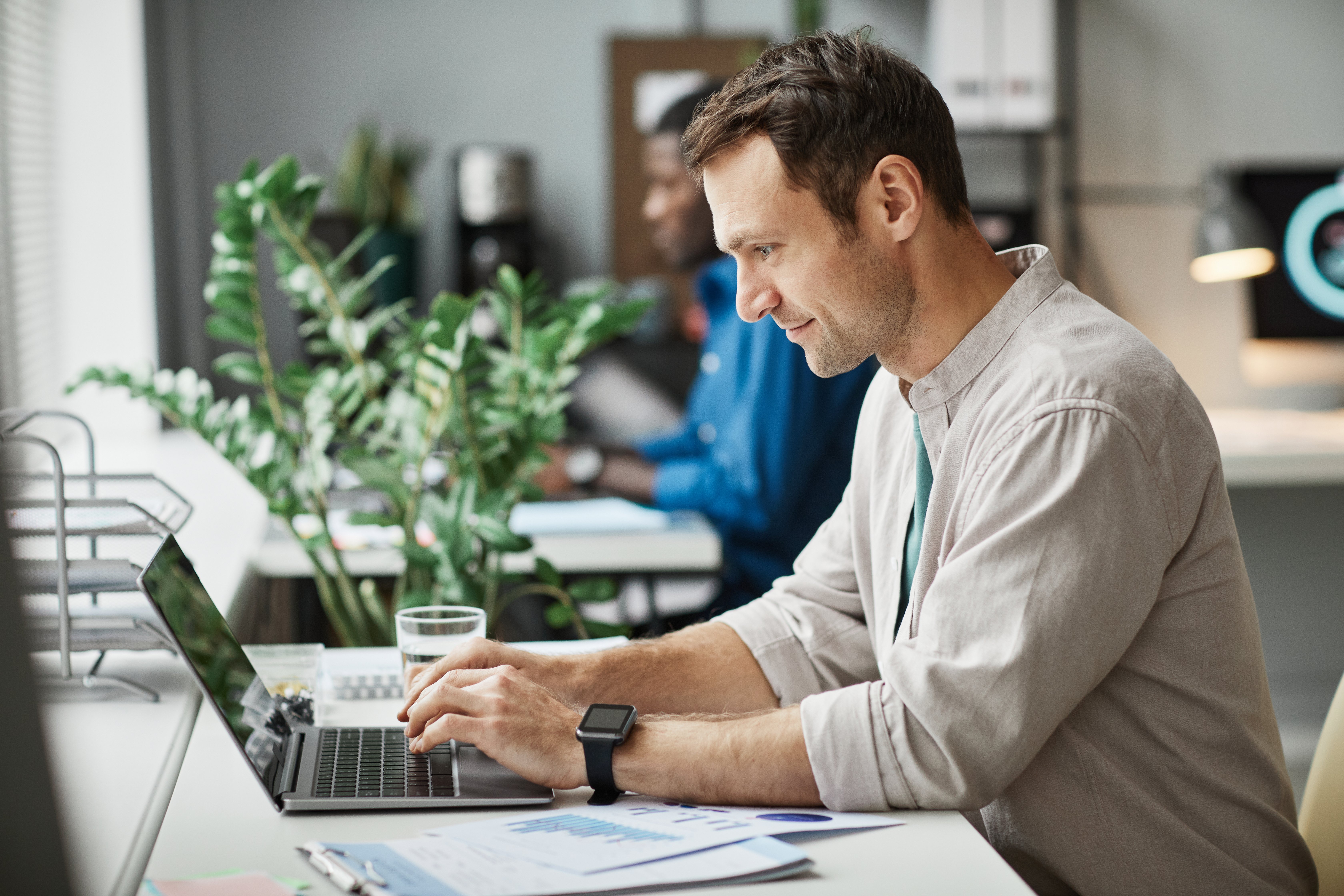 man-working-at-computer-in-office-side-view-2021-12-09-15-18-34-utc